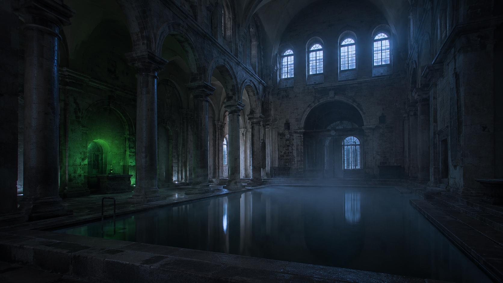 Interior de un gran balneario histórico con arcos de piedra y agua quieta