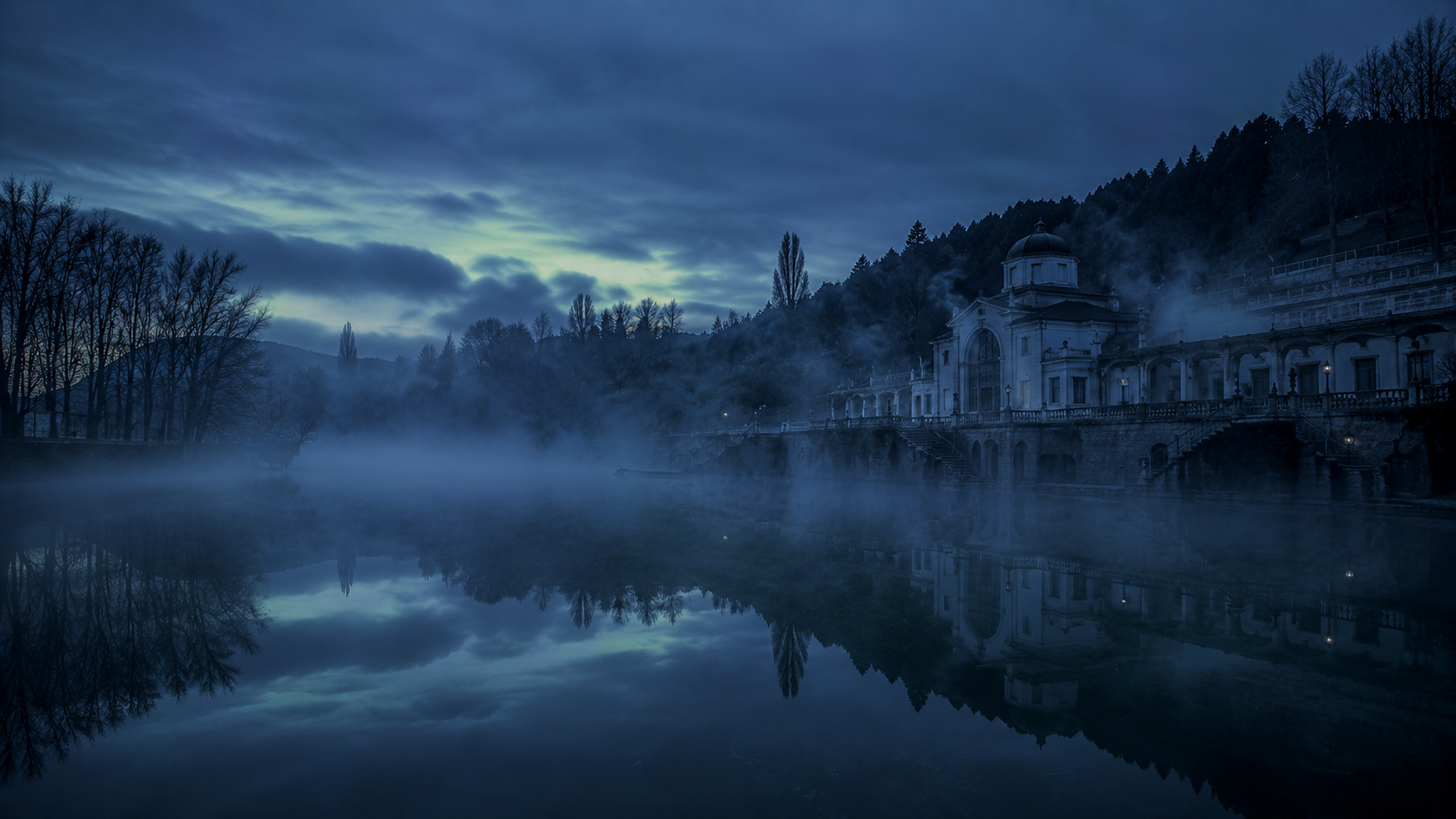 Lago termal natural al aire libre con vapor sobre el agua a la hora azul