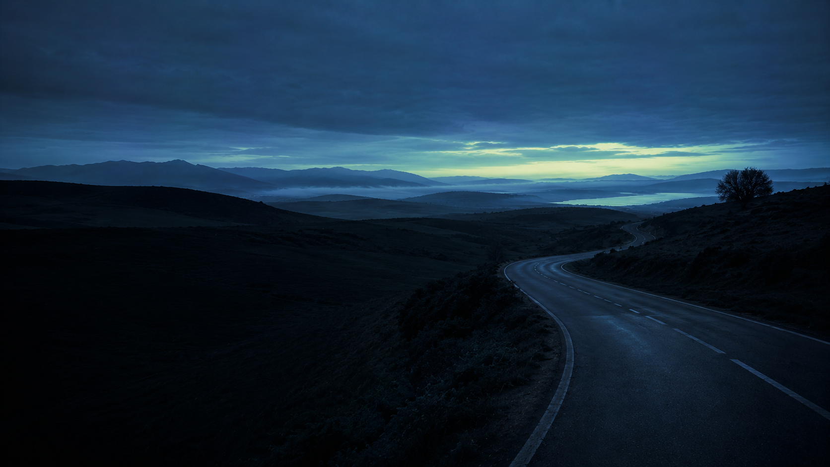 Carretera serpenteando por un paisaje abierto de España a la hora azul, identidad visual de Wellna