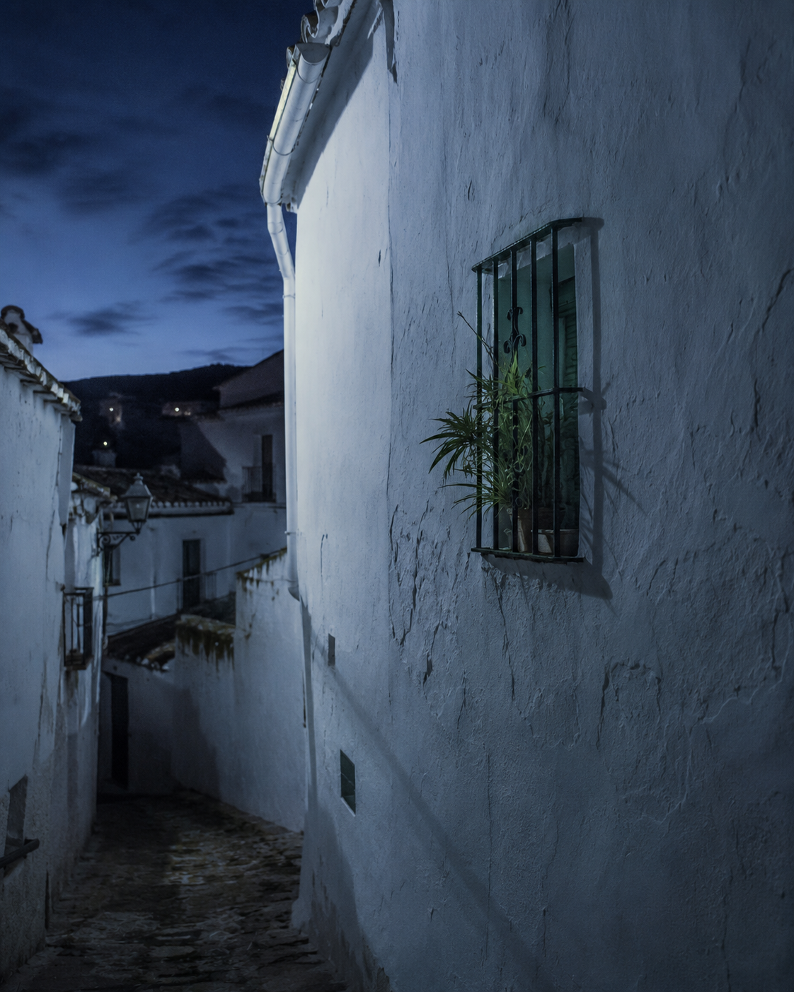 Calle estrecha y encalada del casco histórico de Arcos de la Frontera a la hora azul