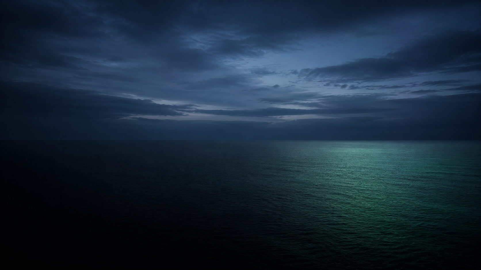 El mar y el horizonte en calma a la hora azul, sin nadie a la vista