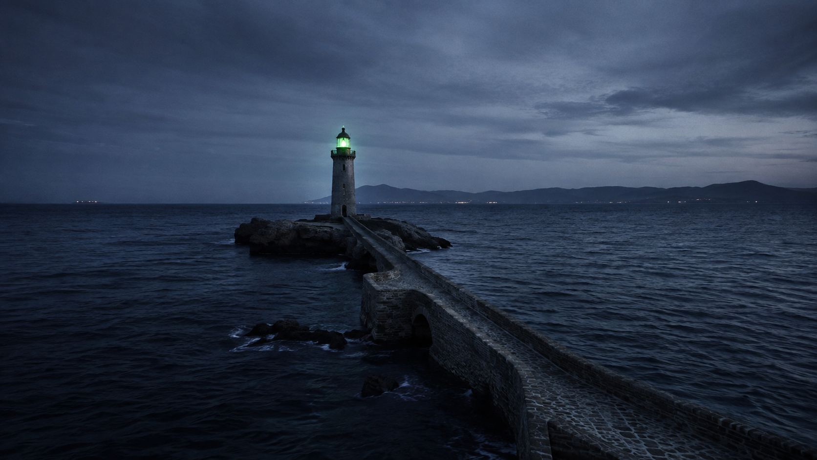 El istmo y el faro de la Punta de Tarifa a la hora azul, con el mar a ambos lados y la costa de África al fondo, sin nadie a la vista