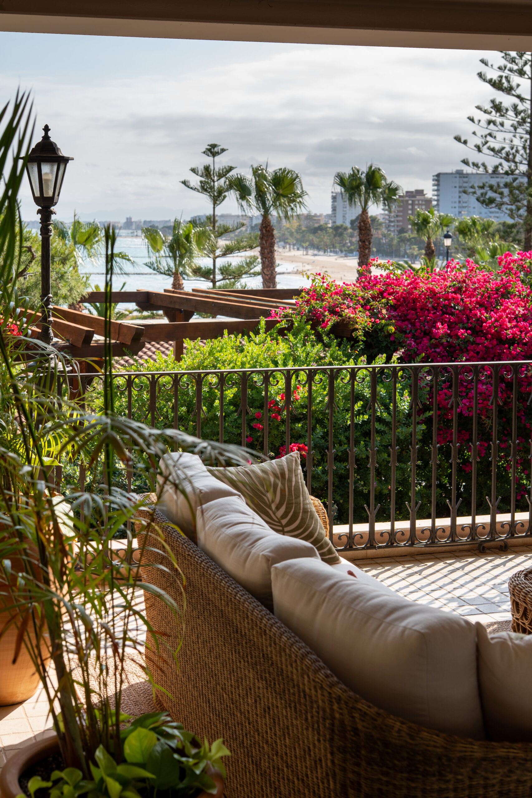 El Mediterráneo y la playa de Benicàssim vistos desde la terraza de Palasiet, con una buganvilla en flor y la barandilla de forja